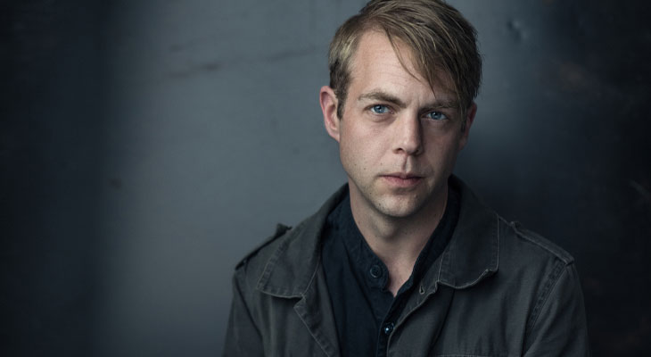 Författaren Christoffer Carlsson tittar in i kameran